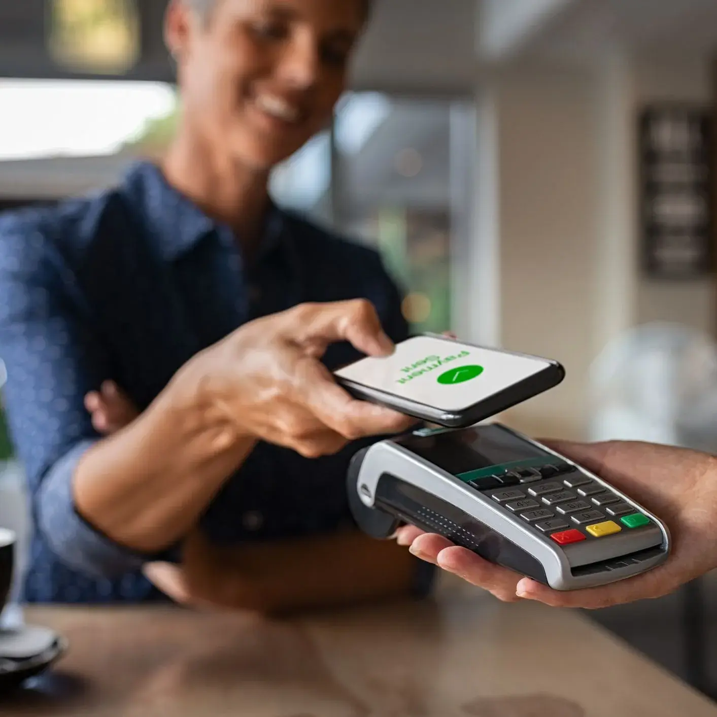 Donna effettua un pagamento tramite smartphone al POS